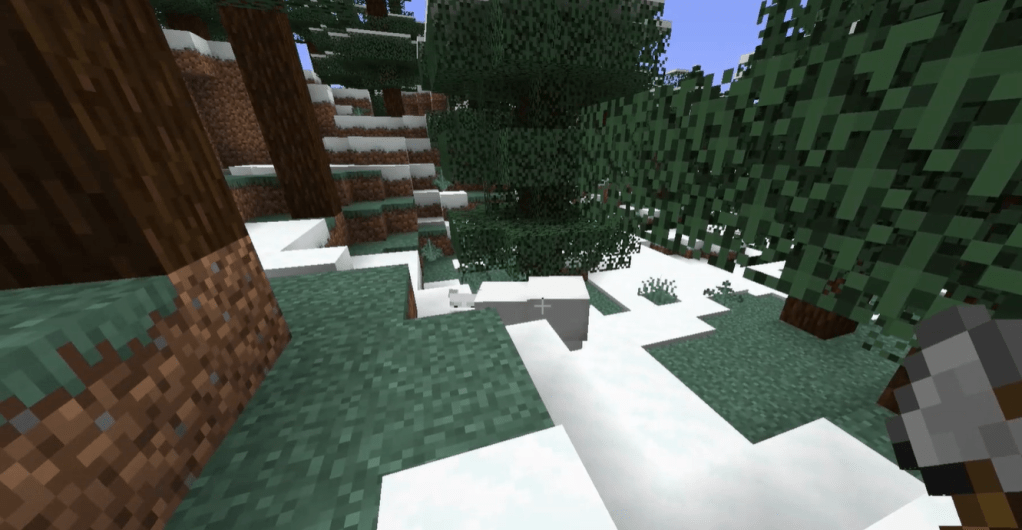 A polar bear looks curiously at the player from just below a small rise in the hill.